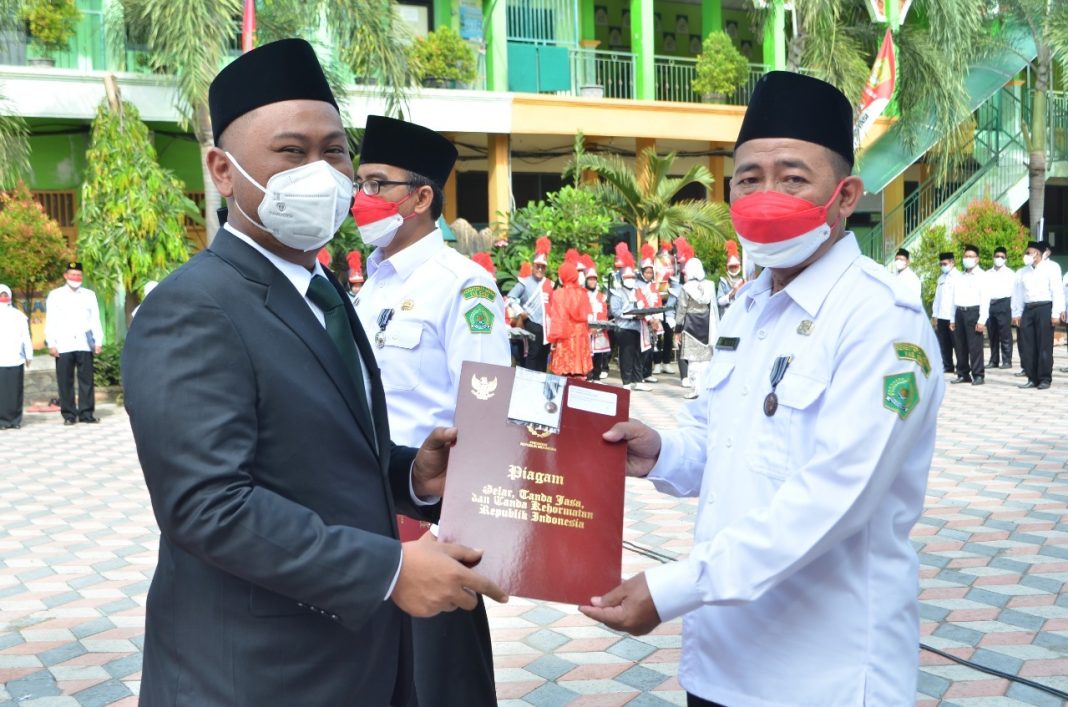 Bupati Gresik Fandi Akhmad Yani saat memberikan penghargaan kepada pegawai Kementerian Agama Kabupaten Gresik, Senin (3/1/2022)./ Foto: tbk