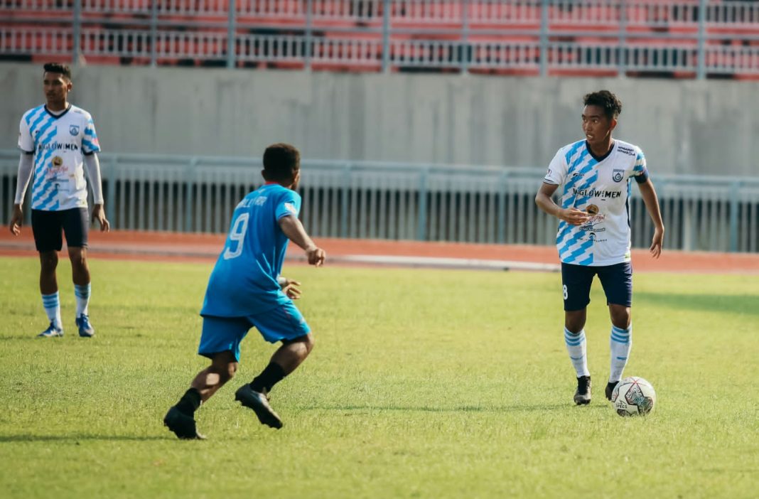 Pemain Gresik United (GU) Rendy Jaya (putih biru) menguasai bola saat kontra Belitong FC dalam laga ujicoba, Rabu (19/1/2022)./ Foto: TBK