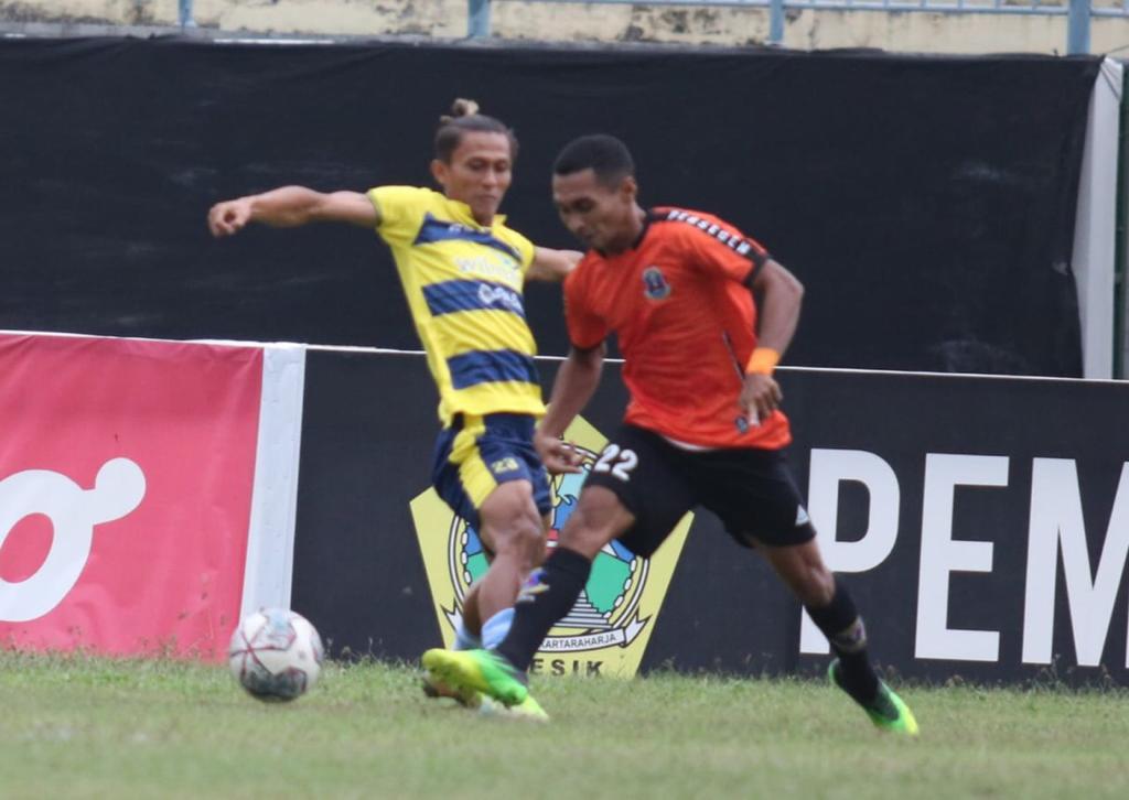 Pemain Gresik United, Muhammad Irvan (kuning) mengawal ketat pemain Perseden Denpasar pada laga Liga 3 Nasional Grup I, Jumat (11/2/2022) di stadion Gelora Joko Samudero. / Foto: TBK